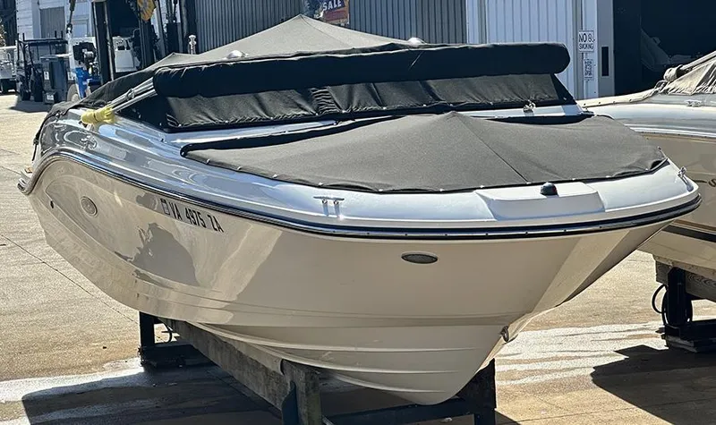 Slide: The Image of 2019 Sea Ray SPX 230 OB boat with black cover, docked on a sunny day. - 6