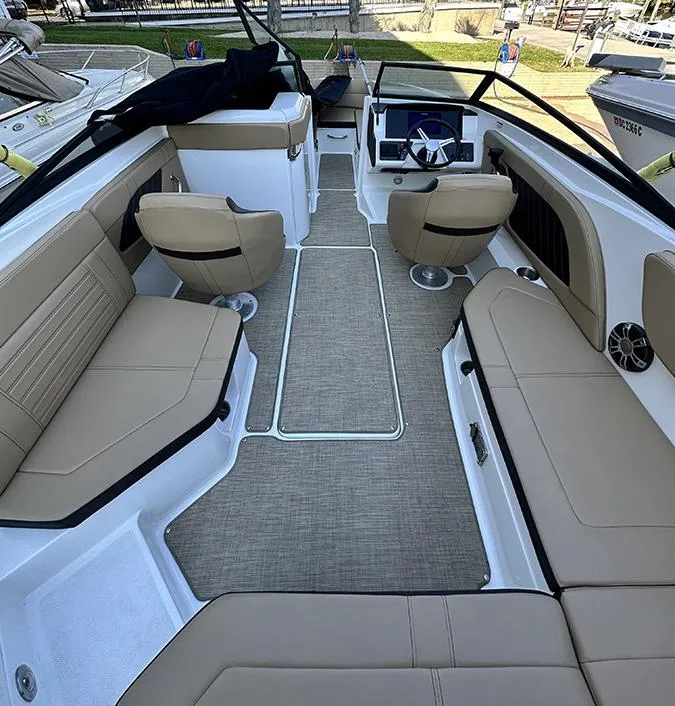 Slide: The Image of 2019 Sea Ray SPX 230 OB boat interior with beige seating and modern dashboard. - 9