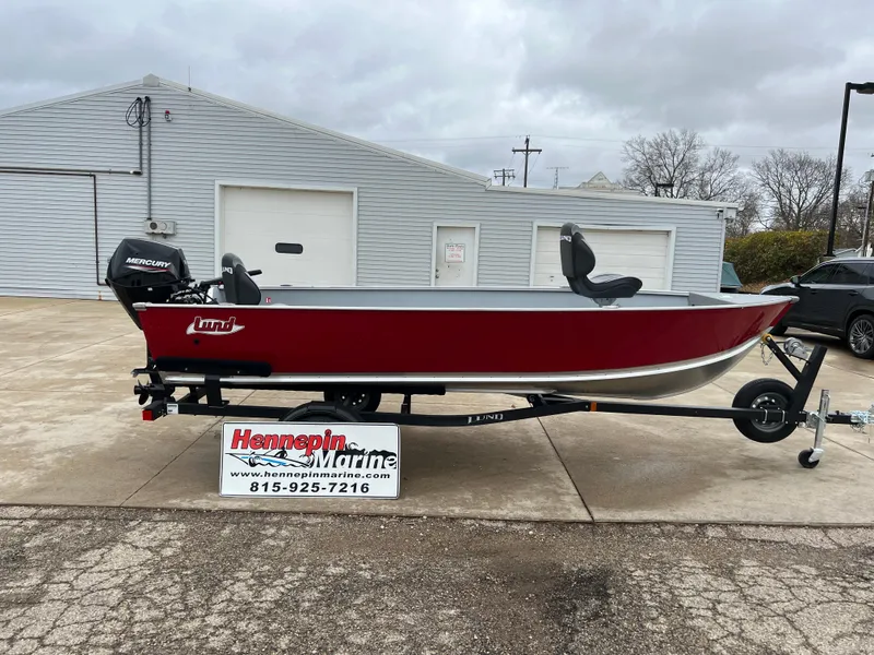 The Image of 2025 Lund 1600 Fury Tiller boat on trailer, red exterior, displayed at Hennepin Marine dealership. - 0