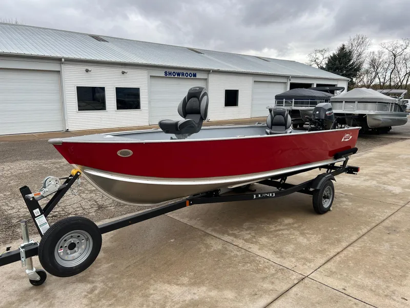Slide: The Image of 2025 Lund 1600 Fury Tiller boat, red, on trailer outside showroom. - 3