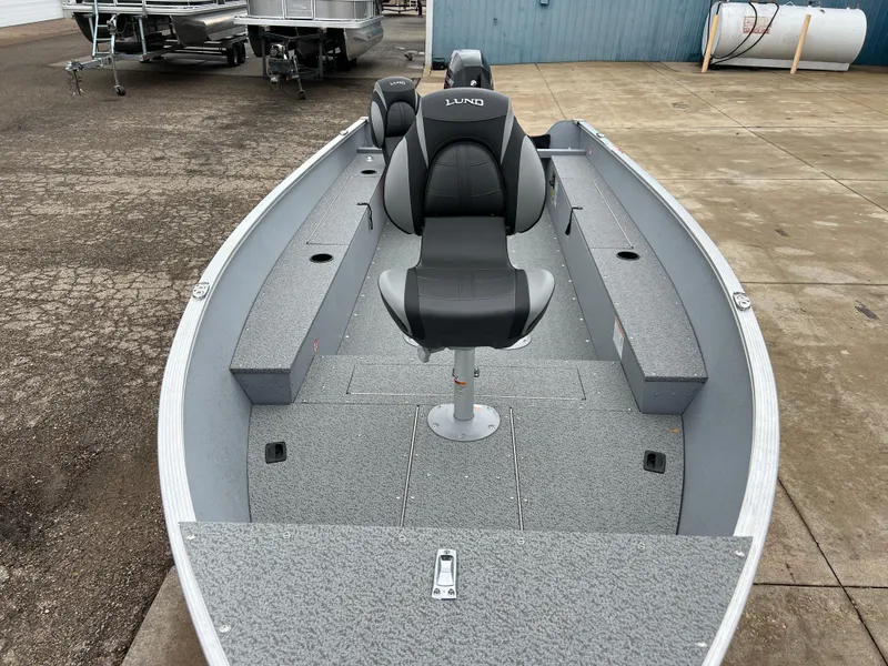 Slide: The Image of 2025 Lund 1600 Fury Tiller boat with seating, docked on concrete surface. - 8