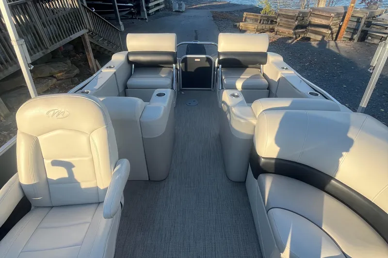 Slide: The Image of 2015 Manitou 25 Oasis SR pontoon boat interior with beige seating and spacious layout. - 4