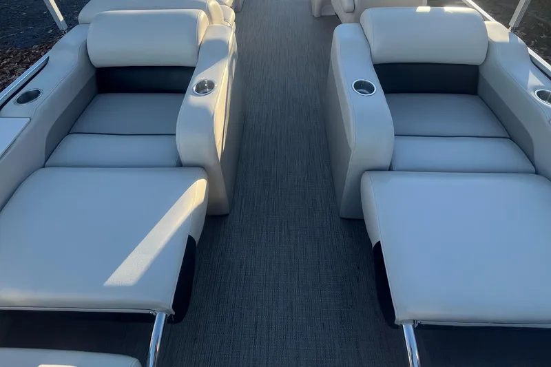 Slide: The Image of 2015 Manitou 25 Oasis SR boat interior with plush seating and cup holders. - 6