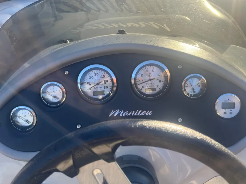 Slide: The Image of Dashboard of a 2015 Manitou 25 Oasis SR boat with gauges and steering wheel. - 8