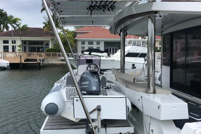 Slide: The Image of Bali 5.4 yacht docked, featuring Yamaha motor, modern design, and waterfront homes in the background. - 11