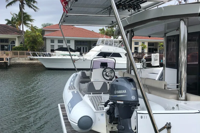 Slide: The Image of Bali 5.4 catamaran docked near waterfront homes, featuring a Yamaha outboard motor. - 12