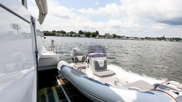 Slide: The Image of Inflatable boat Bali 5.4 (2021) docked on calm water with scenic shoreline view. - 13