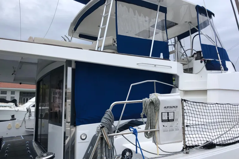 Slide: The Image of 2021 Bali 5.4 yacht with blue canopy, docked at marina. - 14