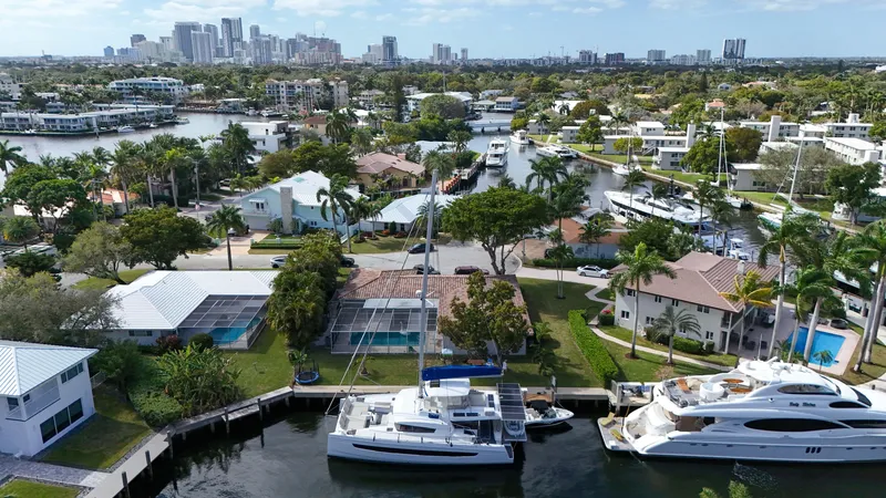 Slide: The Image of Aerial view of luxury yachts and waterfront homes in a tropical cityscape, featuring a Bali 5.4 catamaran. - 34