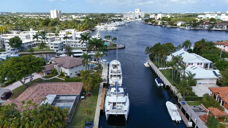 Slide: The Image of Aerial view of a Bali 5.4 catamaran docked in a scenic waterfront neighborhood, 2021. - 36