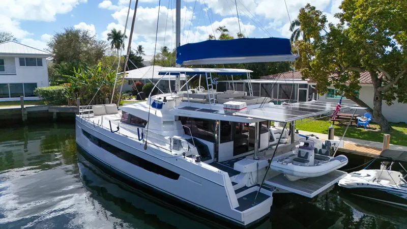 Slide: The Image of 2021 Bali 5.4 catamaran docked by waterfront homes, featuring spacious deck and modern design. - 40