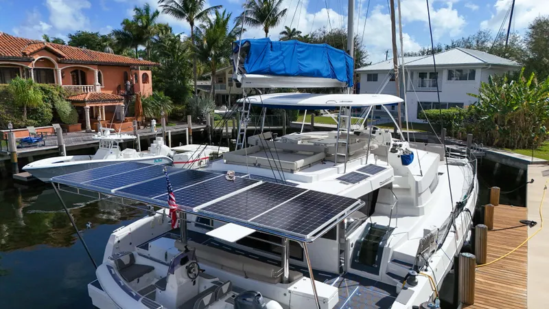 Slide: The Image of Bali 5.4 catamaran docked, featuring solar panels, surrounded by tropical homes and palm trees. - 44