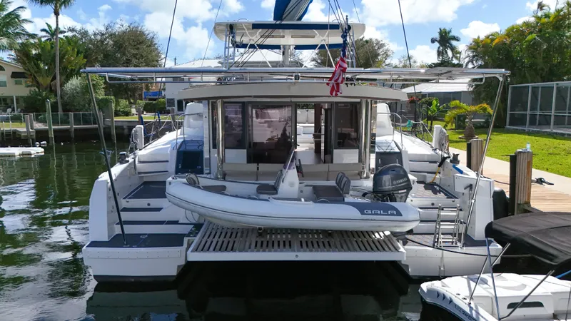 Slide: The Image of Luxury Bali 5.4 catamaran docked, featuring spacious deck and tender boat, 2021 model. - 45