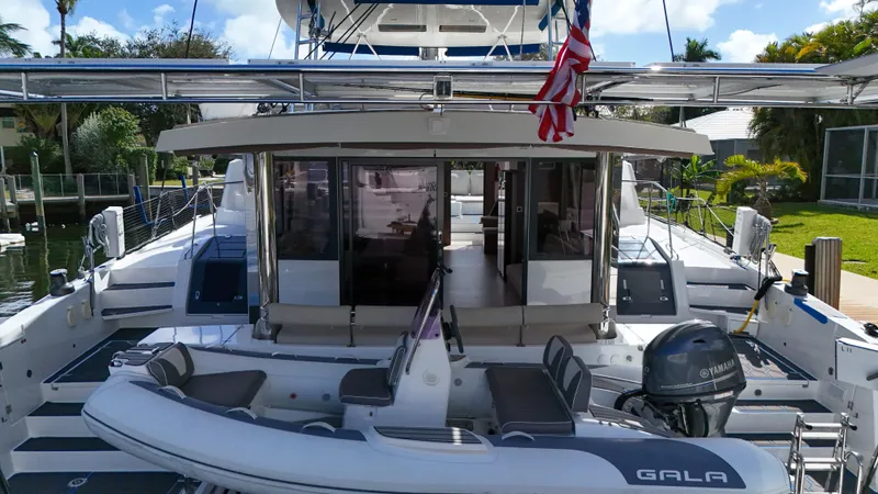 Slide: The Image of Luxury Bali 5.4 catamaran yacht with inflatable boat, docked in a sunny marina, 2021 model. - 46