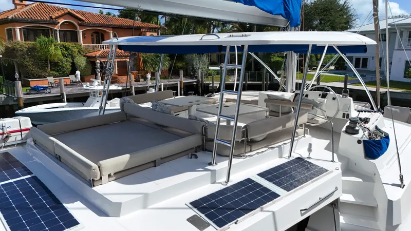 Slide: The Image of 2021 Bali 5.4 catamaran with solar panels, docked near luxury waterfront homes. - 47
