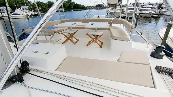 Slide: The Image of Spacious deck of 2021 Bali 5.4 catamaran with seating and tables, docked at marina. - 5
