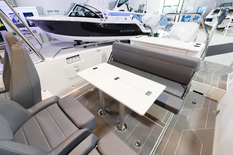 Slide: The Image of 2024 Quarken 27 T-Top V2 boat interior with seating and table in showroom. - 11