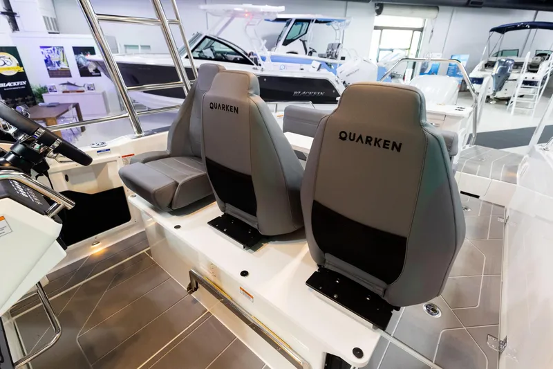 Slide: The Image of 2024 Quarken 27 T-Top V2 boat interior with branded seats in showroom. - 19