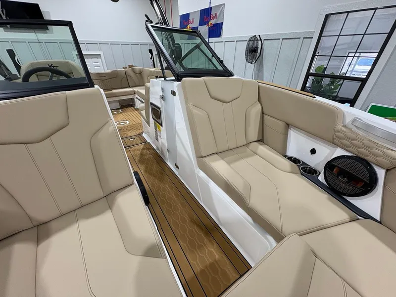 Slide: The Image of 2025 MasterCraft XT22 boat interior with beige seating and wood flooring. - 14