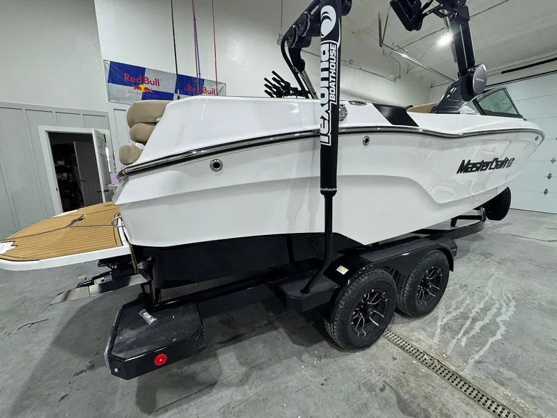 Slide: The Image of 2025 MasterCraft XT22 boat on trailer in indoor garage setting. - 4