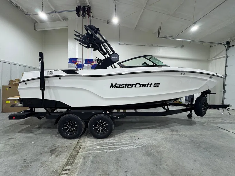 Slide: The Image of 2025 MasterCraft XT22 boat in a showroom, white exterior, on a trailer. - 5