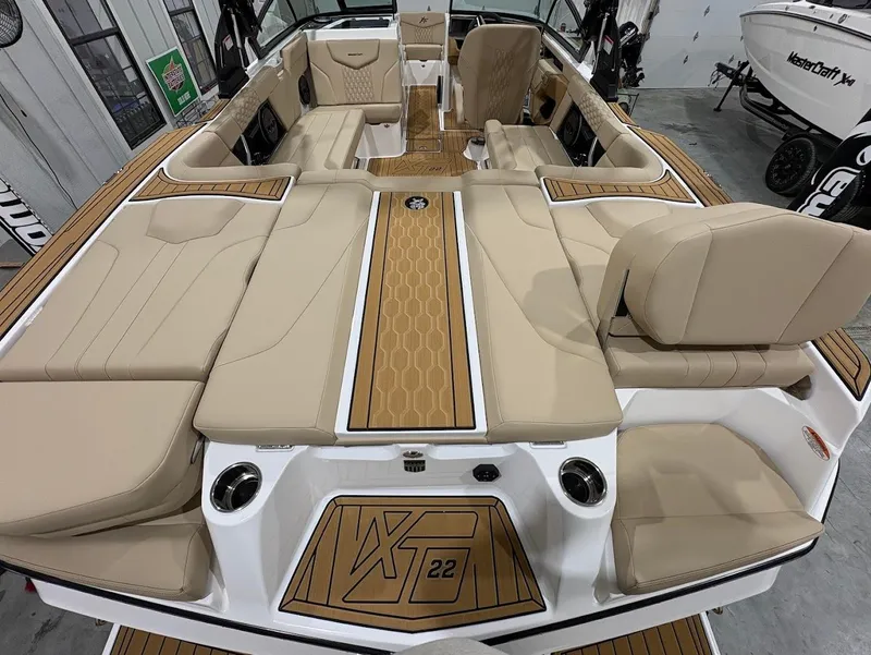 Slide: The Image of 2025 MasterCraft XT22 boat interior with beige seating and wood accents. - 7