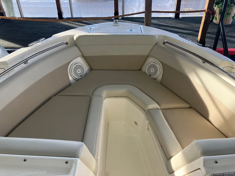 Slide: The Image of 2025 Boston Whaler 210 Vantage boat interior with beige seating and built-in speakers. - 10