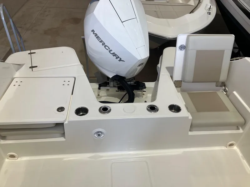 Slide: The Image of 2025 Boston Whaler 210 Vantage boat with Mercury engine, featuring seating and cup holders. - 4