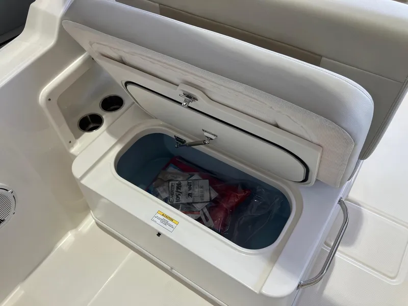 Slide: The Image of 2025 Boston Whaler 210 Vantage boat seat storage compartment with safety gear inside. - 6