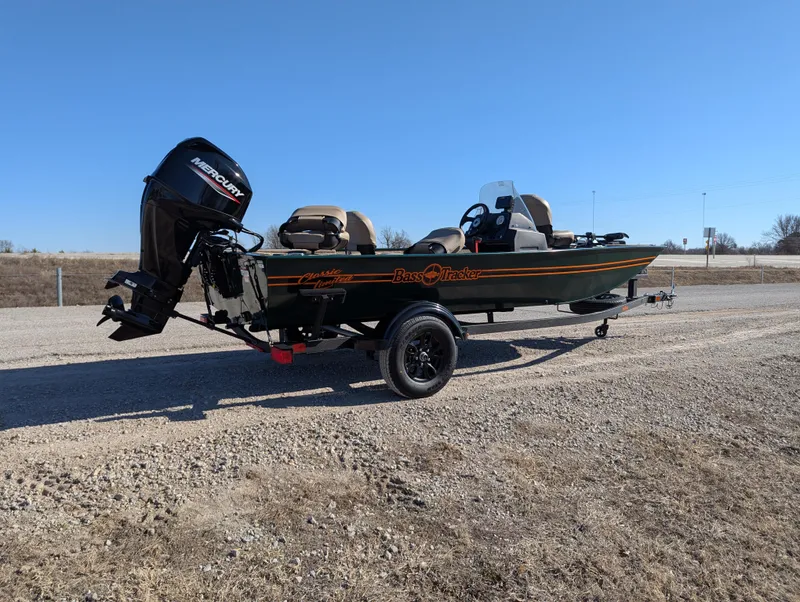 Slide: The Image of 2025 Tracker Bass Tracker Classic Limited boat on a gravel road under clear blue sky. - 45