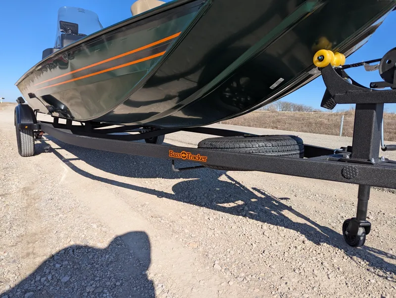 Slide: The Image of 2025 Tracker Bass Tracker Classic Limited boat on trailer, parked on gravel road. - 48