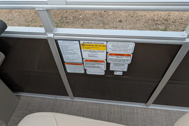 Slide: The Image of 2025 Sun Tracker SportFish 20 DLX capacity and warning labels on boat interior. - 100