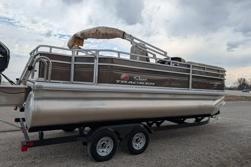 Slide: The Image of 2025 Sun Tracker SportFish 20 DLX pontoon boat on trailer under cloudy sky. - 87