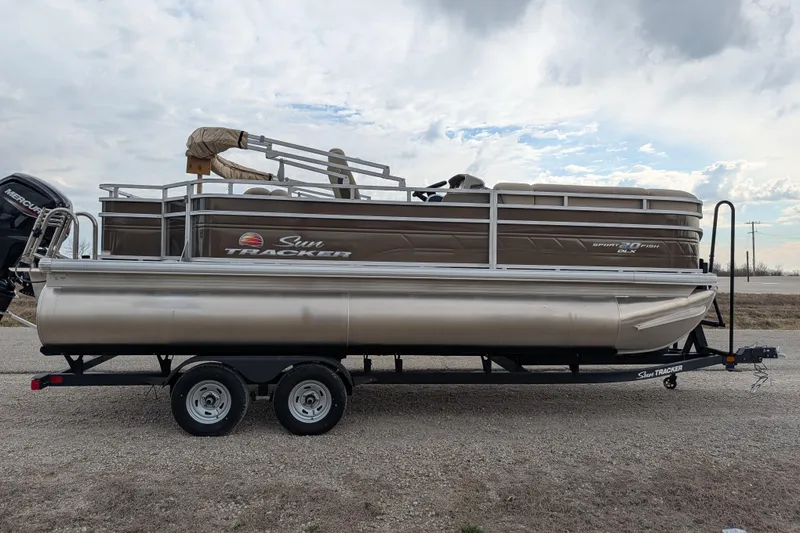 Slide: The Image of 2025 Sun Tracker SportFish 20 DLX pontoon boat on trailer, parked outdoors. - 88