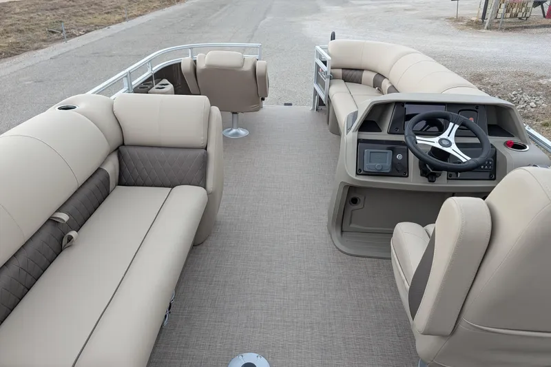 Slide: The Image of 2025 Sun Tracker SportFish 20 DLX pontoon boat interior with beige seating and steering console. - 98