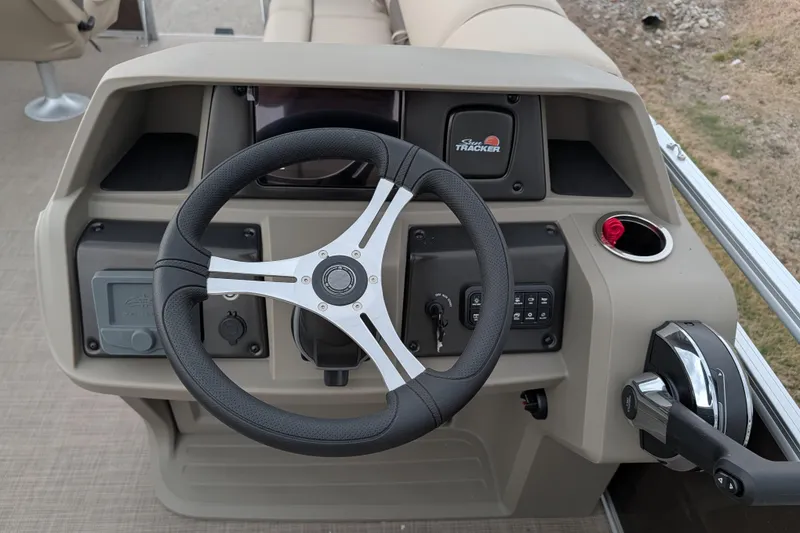 Slide: The Image of 2025 Sun Tracker SportFish 20 DLX boat dashboard with steering wheel and controls. - 99