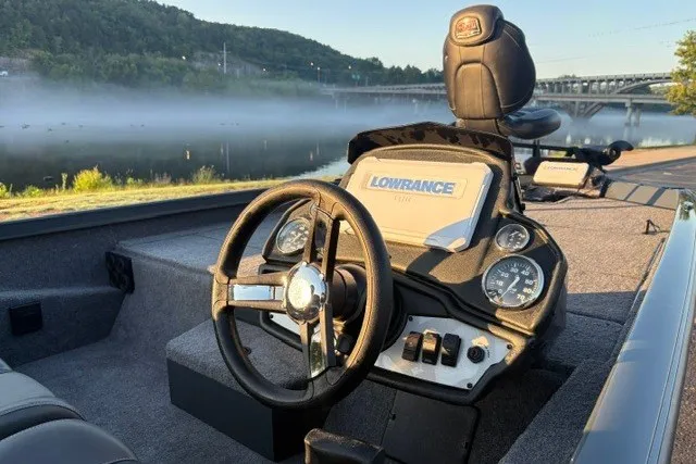 Slide: The Image of 2025 Ranger RT198P boat interior with steering wheel and Lowrance electronics by a misty river. - 27