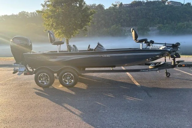Slide: The Image of 2025 Ranger RT198P boat on trailer, parked by misty lake at sunrise. - 3