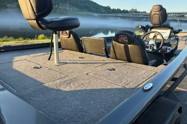 Slide: The Image of 2025 Ranger RT198P fishing boat interior with seats and steering, near a serene river. - 28
