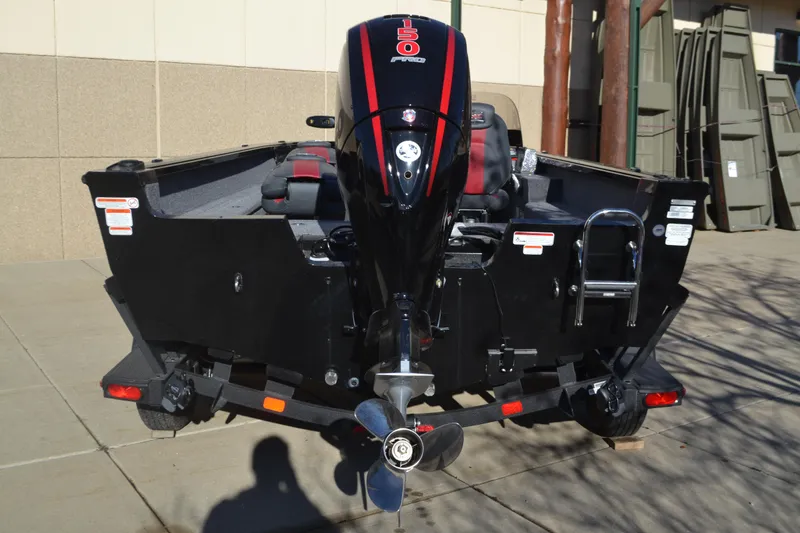 Slide: The Image of 2025 Ranger VS1882SC Angler boat, rear view with motor and propeller, parked outdoors. - 2