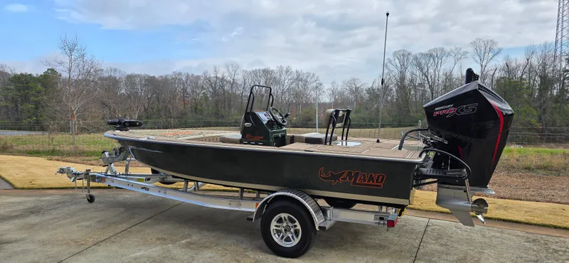 Slide: The Image of 2025 Mako 18 Pro Skiff Backwater Edition boat on trailer, parked outdoors. - 1