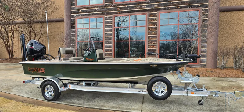 Slide: The Image of 2025 Mako 18 Pro Skiff Backwater Edition boat on trailer, parked outside a building. - 3