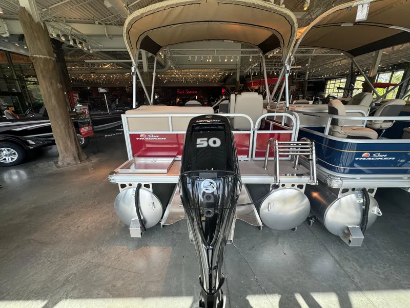 Slide: The Image of 2025 Sun Tracker Bass Buggy 16 XL Select pontoon boat with 50 HP engine in showroom. - 3