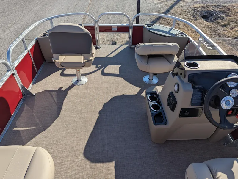Slide: The Image of 2025 Sun Tracker Bass Buggy 18 DLX pontoon boat interior with seating and steering console. - 11