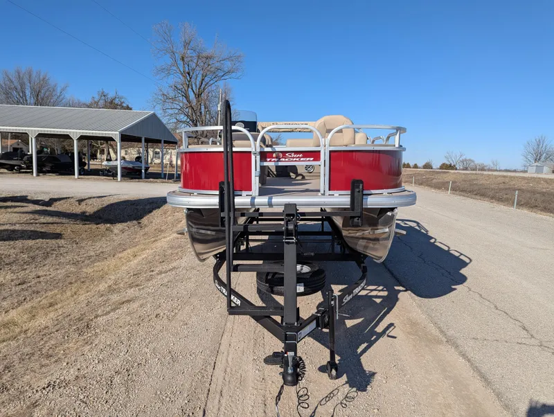Slide: The Image of 2025 Sun Tracker Bass Buggy 18 DLX pontoon boat on trailer, parked on a sunny day. - 8