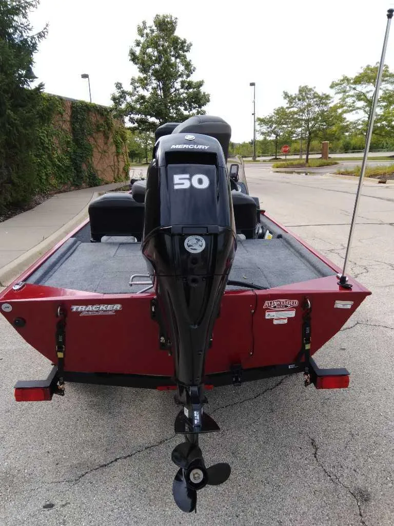 Slide: The Image of 2025 Tracker Bass Tracker Classic XL boat with 50 HP engine, parked outdoors. - 2