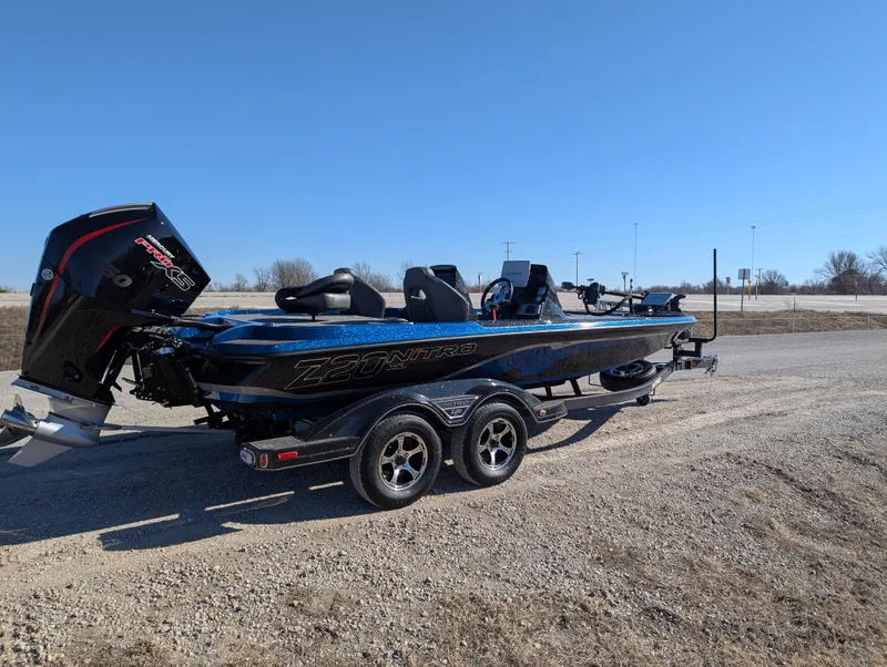 Slide: The Image of 2025 Nitro Z20 XL Pro boat on trailer, parked on gravel road under clear blue sky. - 6