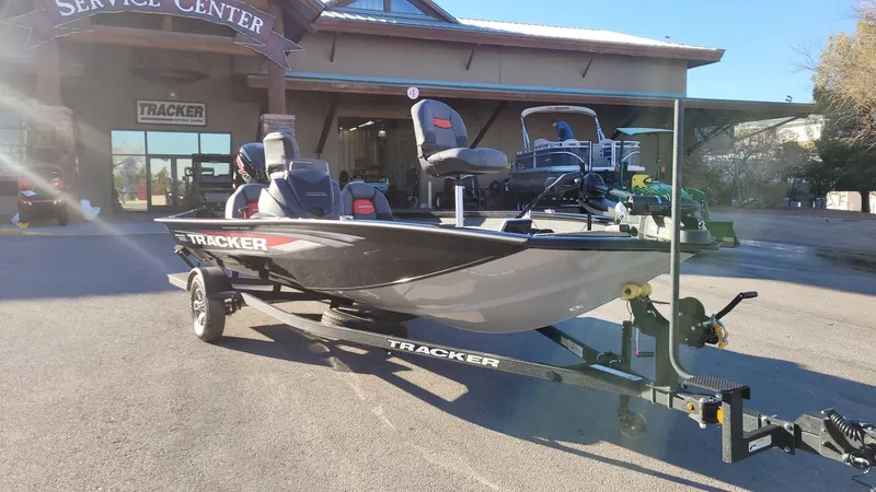 Slide: The Image of 2025 Tracker Pro Team 190 boat on trailer outside service center. - 2