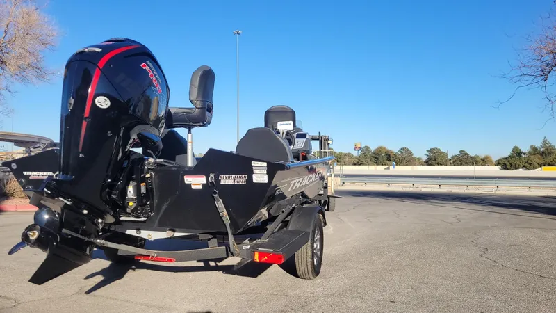 Slide: The Image of 2025 Tracker Pro Team 190 boat with motor on trailer, parked outdoors. - 6
