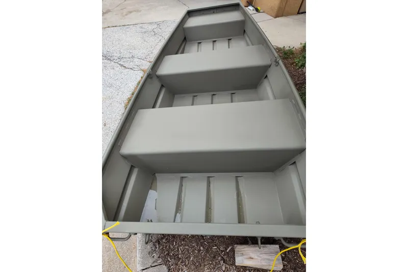 Slide: The Image of 2025 Tracker Grizzly 1036 Utility boat, interior view, parked on concrete surface. - 3